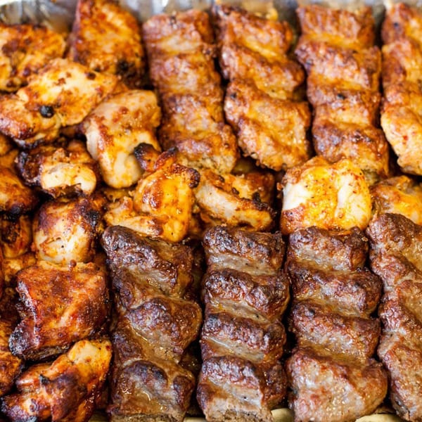 Close-up of grilled chicken and beef kebabs, showcasing their rich, savory textures and golden-brown char.
